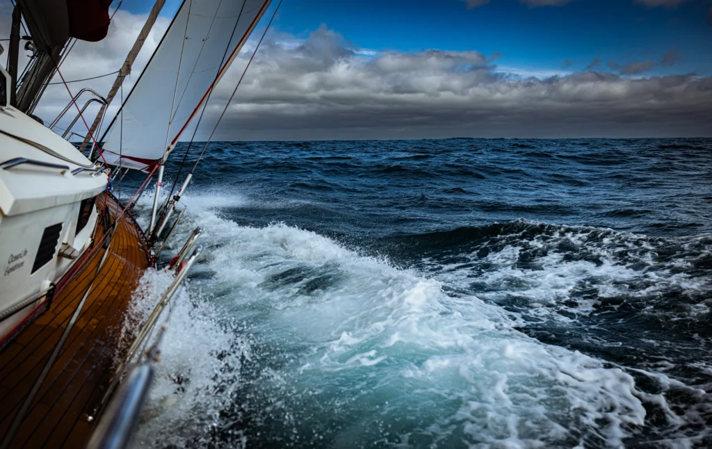 Die „Performance Passage“ mit Profiskipper, Etappe 2 – 261011, segelt unter bewölktem Himmel durch unruhige Wellen.
